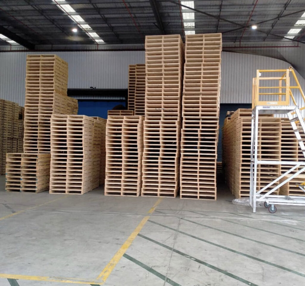 new wood pallets stacked outside with Crate n Pack logo in background